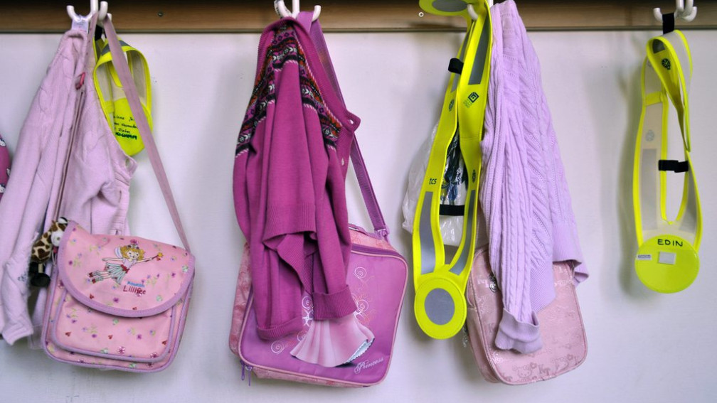 Jacken und Taschen hängen an der Garderobe in einer Schule