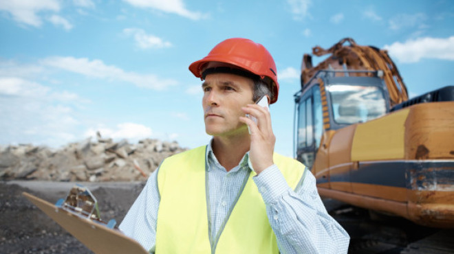 Arbeiter in gelber Weste telefoniert