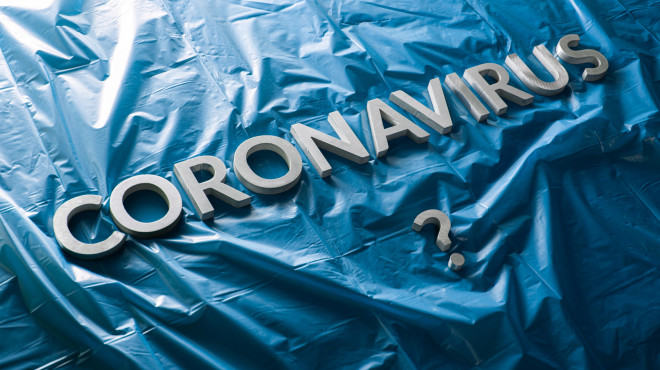 Schriftzug "Coronavirus" auf blauer Plastikplane