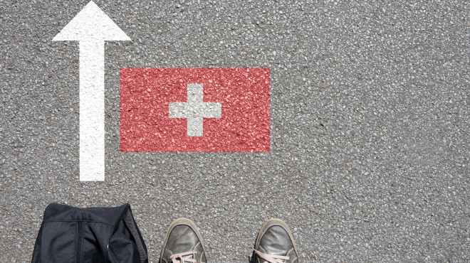 Mann mit Koffer reist in die Schweiz ein
