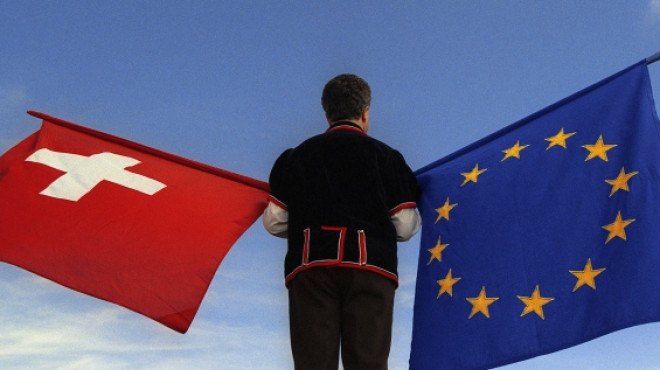 Mann schwingt EU und Schweizer Fahne
