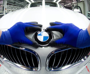 Hände umschliessen BMW-Symbol auf Auto