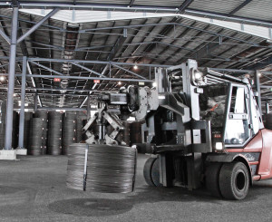 Traktor transportiert Reycling-Tonne in Industriehalle